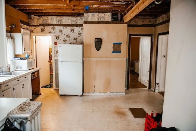 a kitchen with granite countertop a sink cabinets stainless steel appliances and a window