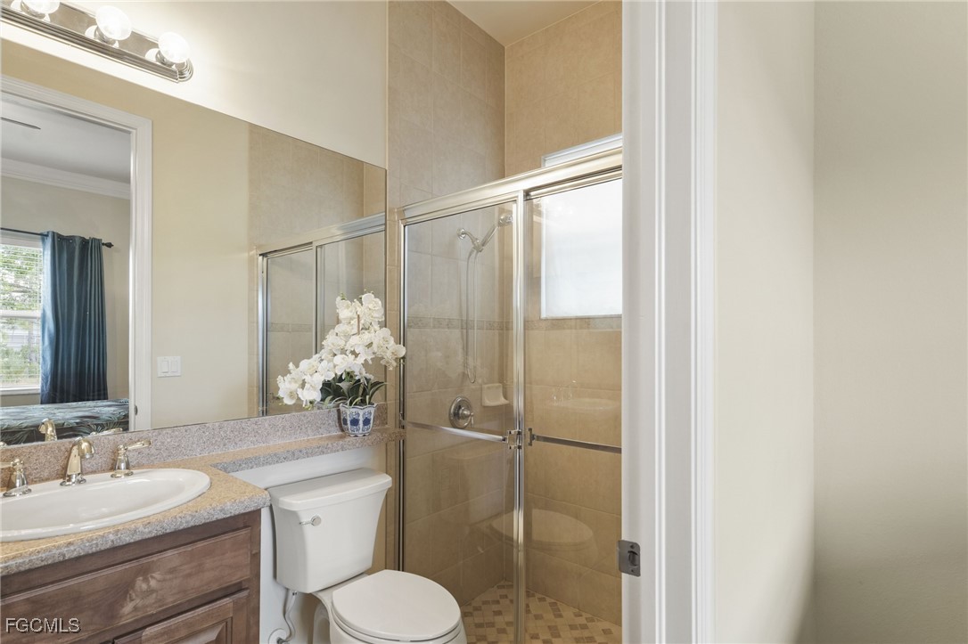 11040 Yellow Poplar Drive Fort Myers, FL 33913 - Photo 13 of 35 a bathroom with a granite countertop sink toilet a mirror and shower