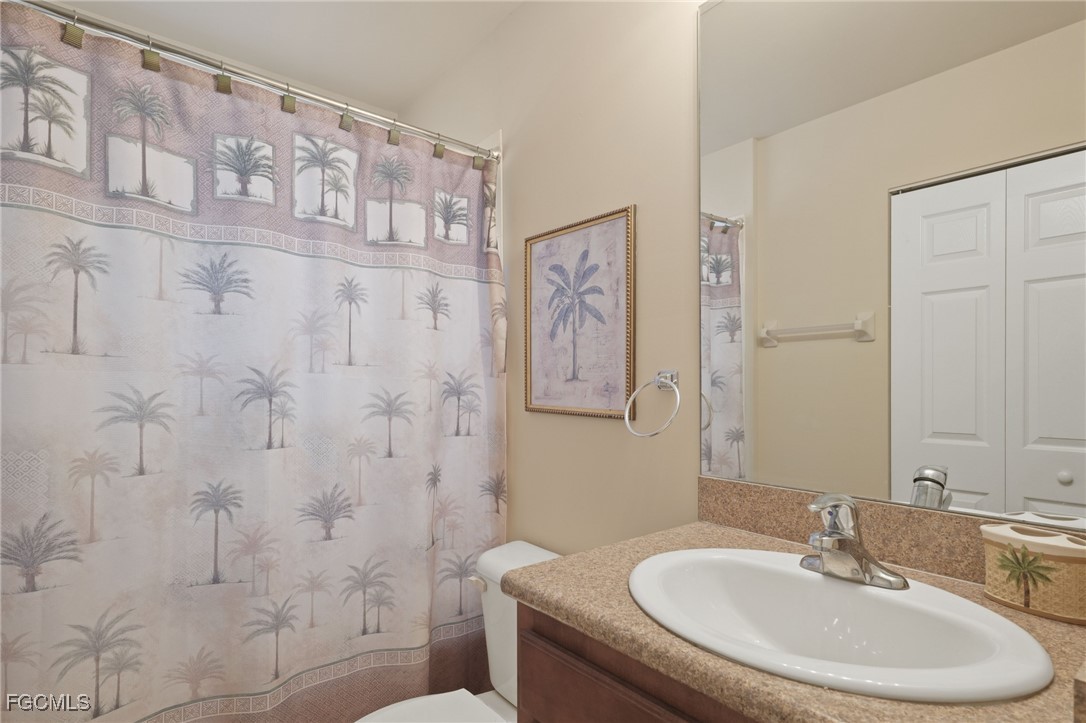 11040 Yellow Poplar Drive Fort Myers, FL 33913 - Photo 15 of 35 a bathroom with a sink a toilet and shower curtain