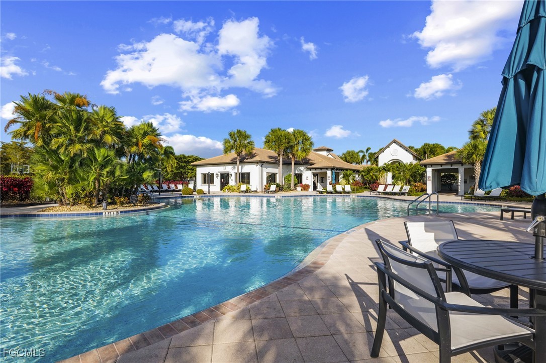 11040 Yellow Poplar Drive Fort Myers, FL 33913 - Photo 25 of 35 a view of a lake with couches chairs and swimming pool in back