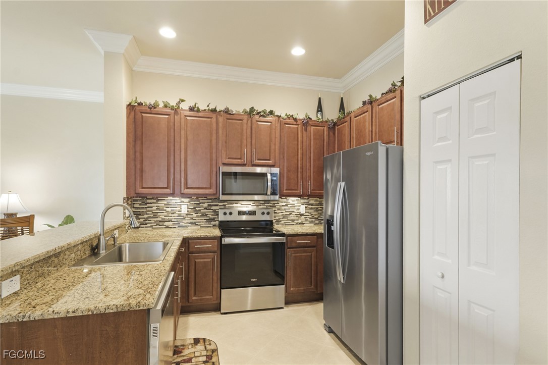 11040 Yellow Poplar Drive Fort Myers, FL 33913 - Photo 6 of 35 a kitchen with stainless steel appliances granite countertop a refrigerator a stove a sink and a microwave