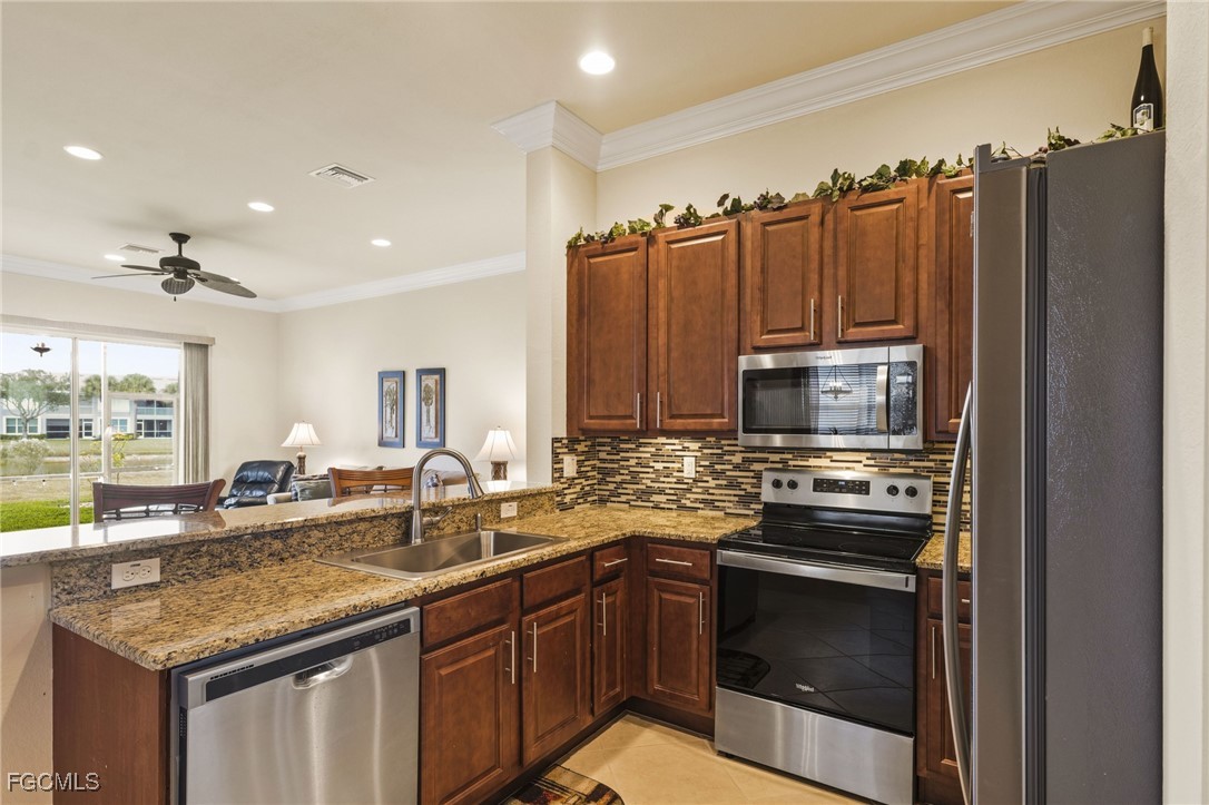 11040 Yellow Poplar Drive Fort Myers, FL 33913 - Photo 7 of 35 a kitchen with stainless steel appliances granite countertop a sink stove and refrigerator