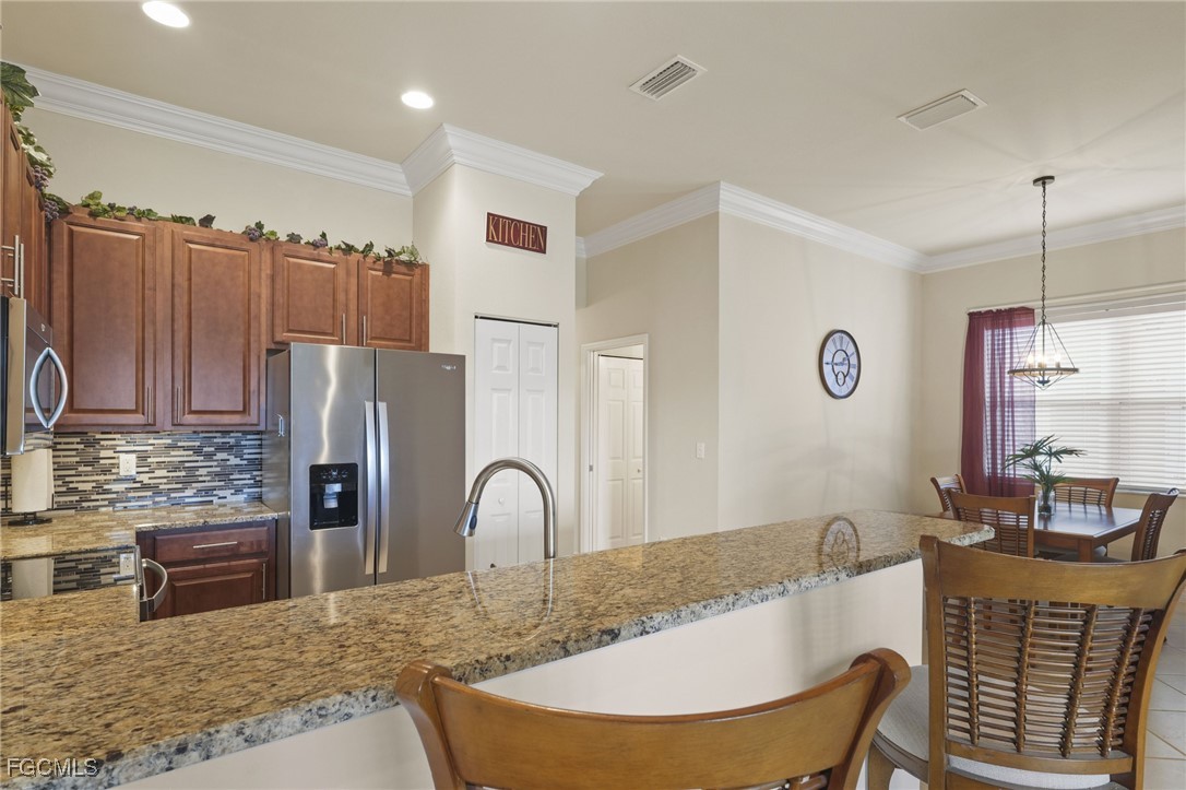 11040 Yellow Poplar Drive Fort Myers, FL 33913 - Photo 8 of 35 a kitchen with stainless steel appliances granite countertop a refrigerator a stove and a sink with wooden floor