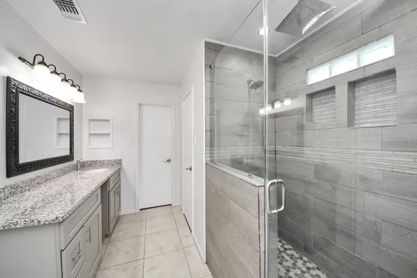a bathroom with a granite countertop sink mirror and shower