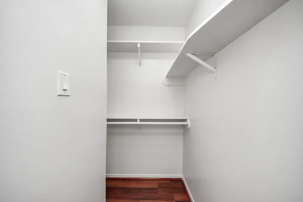 a view of walk in closet with empty racks
