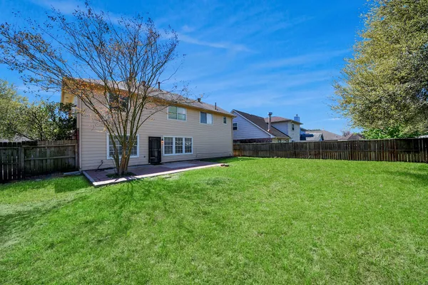 a view of a house with backyard and a tree