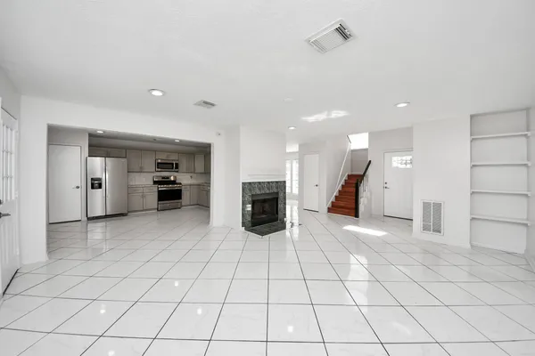 a view of a electric appliances in kitchen and empty room with wooden floor