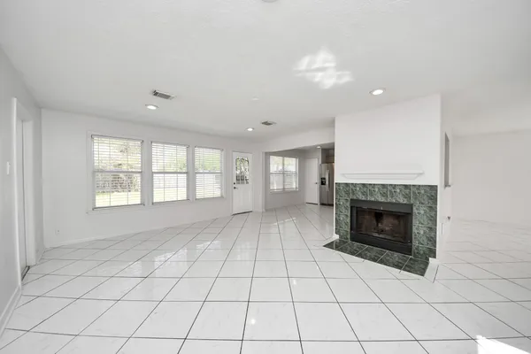 a view of an empty room with a fireplace and a window