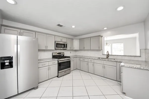 a kitchen with white cabinets stainless steel appliances and a window