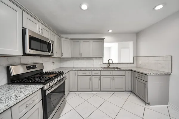 a kitchen with stainless steel appliances granite countertop a sink and stove top oven