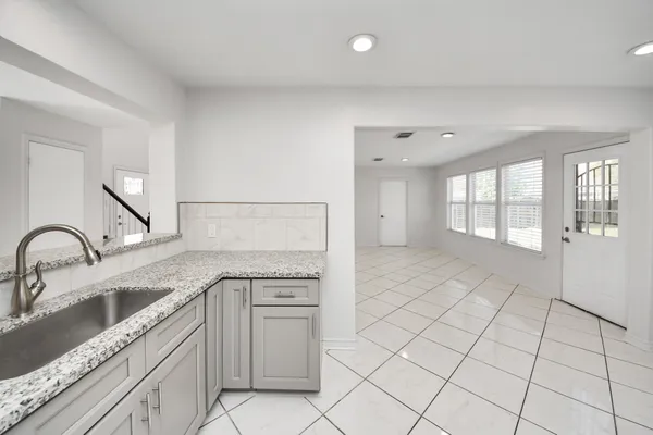 a kitchen with granite countertop a sink and cabinets