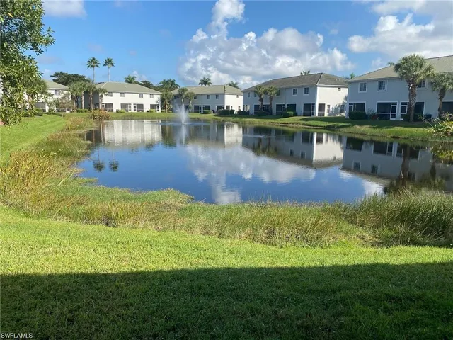 a view of a large building next to a lake with houses