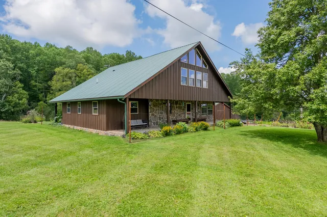 a front view of a house with a garden and trees