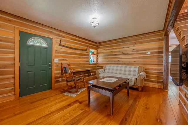 a kitchen with stainless steel appliances granite countertop wooden floors wooden cabinets a dining table and chairs