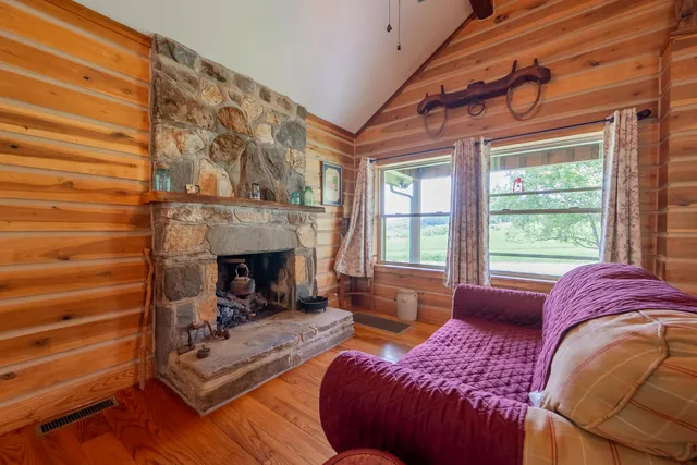 a living room with furniture a flat screen tv and floor to ceiling window