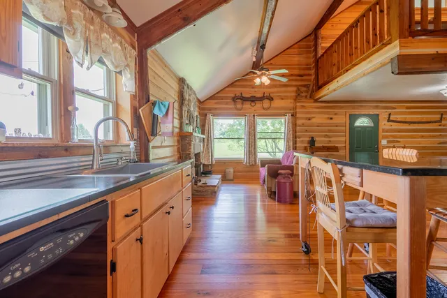 a bedroom with a bed dresser and a large window