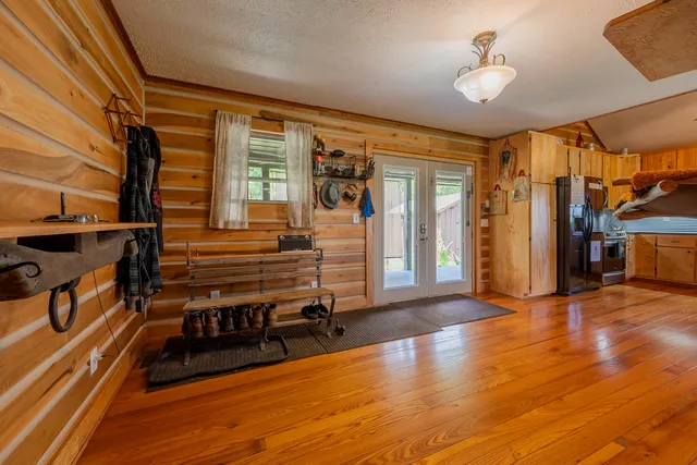 a living room with furniture a flat screen tv and floor to ceiling window