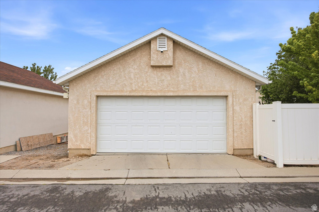 11859 Preamble Road Draper, UT 84020 - Photo 30 of 30 Single-bay garage featuring a stucco exterior and white overhead door