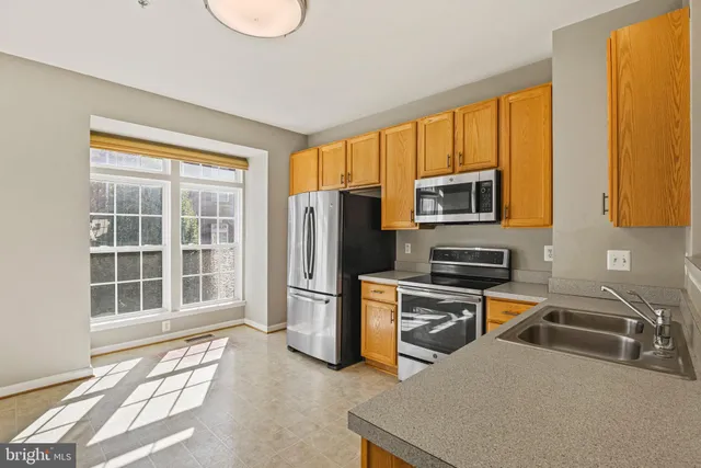 a kitchen that has a microwave a stove and a sink