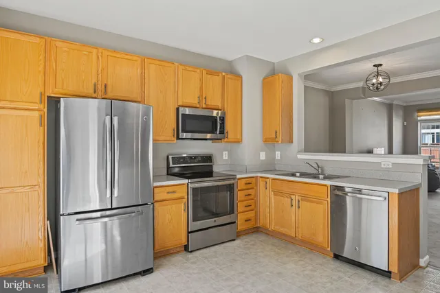 a kitchen with stainless steel appliances granite countertop a refrigerator a stove a sink a washer dryer and white cabinets