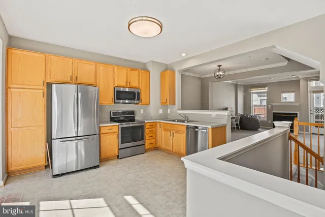 a kitchen with stainless steel appliances granite countertop a refrigerator a sink dishwasher a stove and a refrigerator