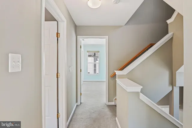 a view of hallway with stairs and wooden floor