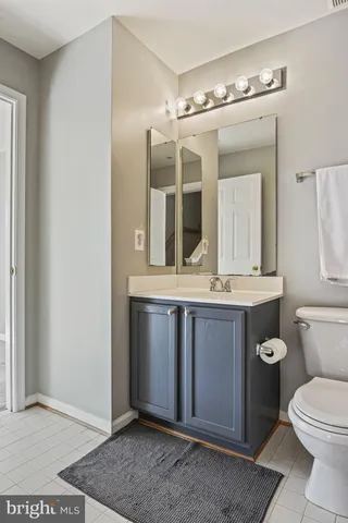 a bathroom with a toilet a sink and mirror