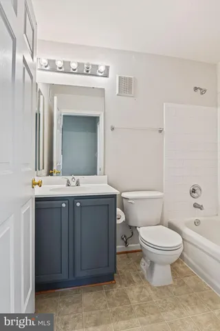 a bathroom with a granite countertop toilet a sink and a mirror