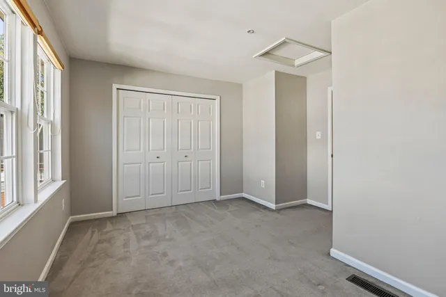 an empty room with windows and closet