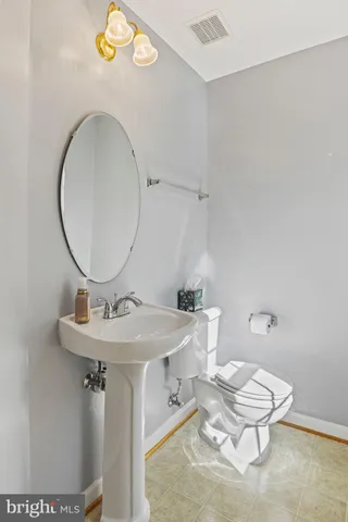 a bathroom with a toilet a sink and a mirror