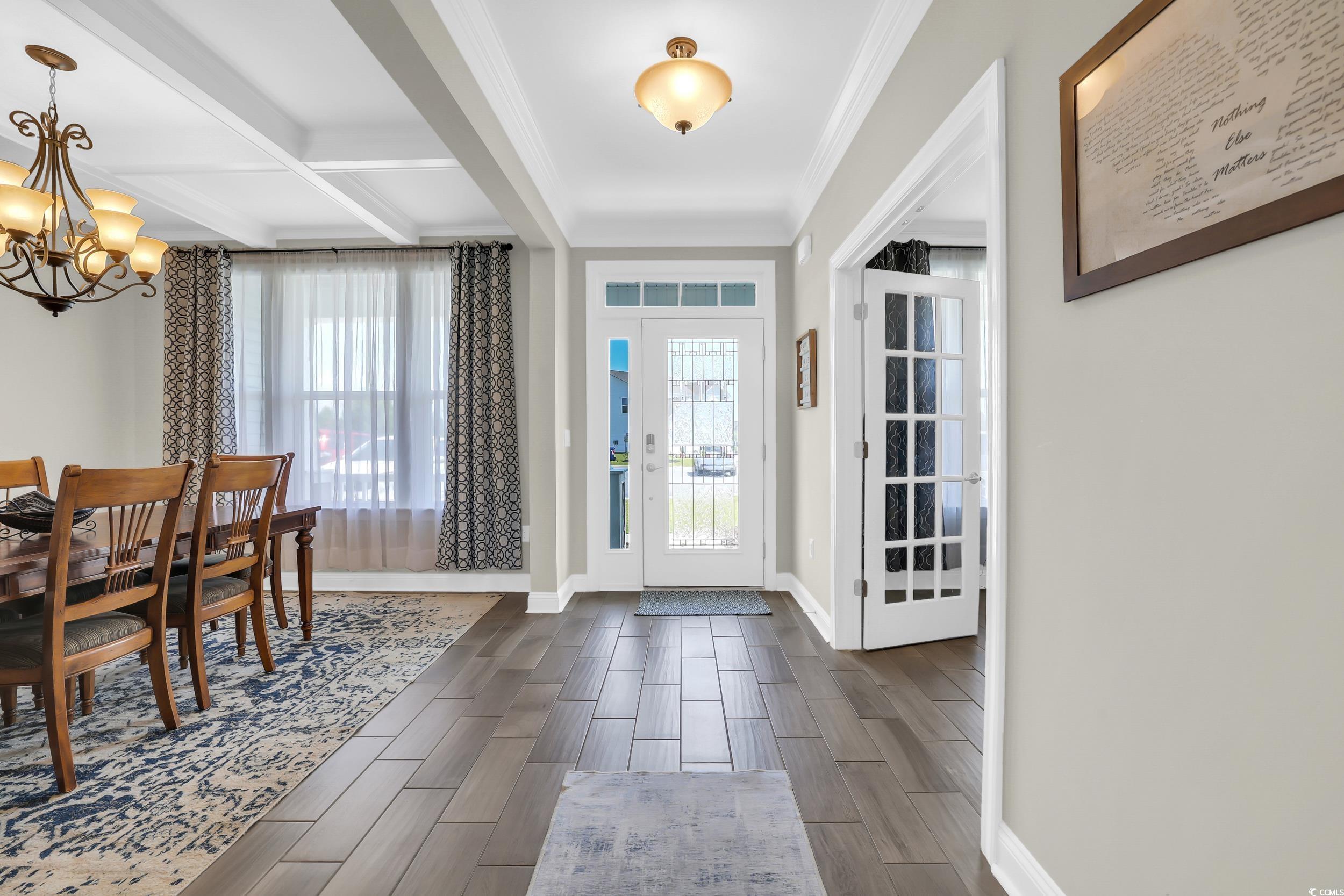 259 Hull Street Surfside Beach, SC 29575 - Photo 5 of 40 Foyer entrance featuring a chandelier, wood tiled floors, crown molding, beam ceiling, and coffered ceiling