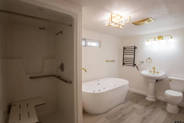 a bathroom with a tub a toilet and a shower