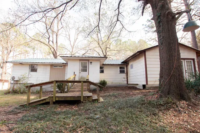 a view of a house with backyard and trees