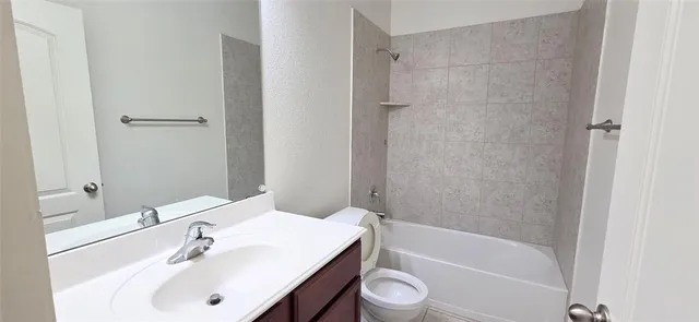 a bathroom with a white bath tub a sink and a toilet