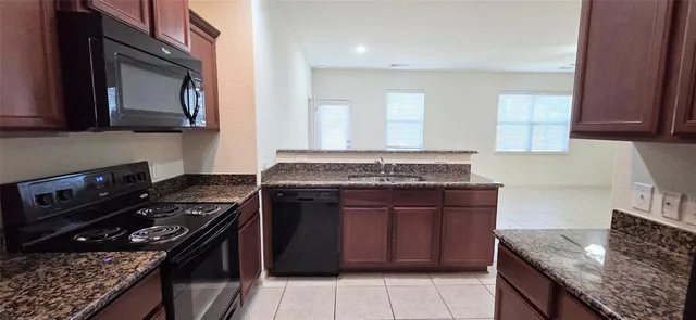 a kitchen with granite countertop a stove and a sink