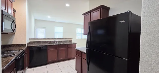 a kitchen with stainless steel appliances granite countertop a refrigerator and a stove