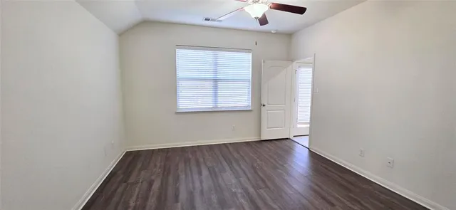 an empty room with a hardwood and ceiling fan