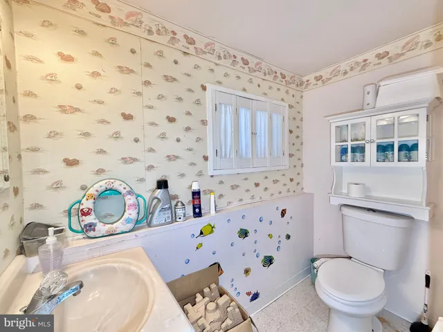 a bathroom with a toilet a sink and a shower curtain