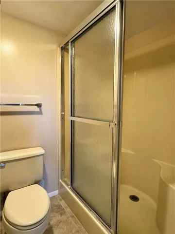 a bathroom with a toilet and a shower