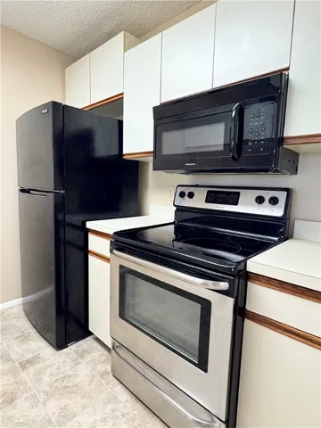 a kitchen with granite countertop a stove and a microwave