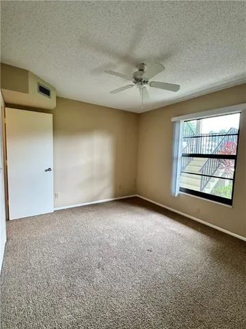 an empty room with closet and a chandelier fan