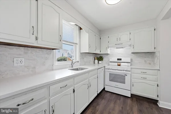 a kitchen with white cabinets and white appliances