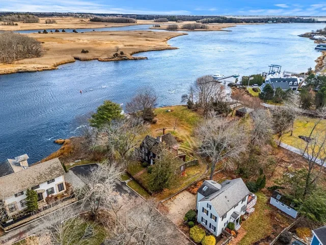 an aerial view of ocean and residential houses with outdoor space