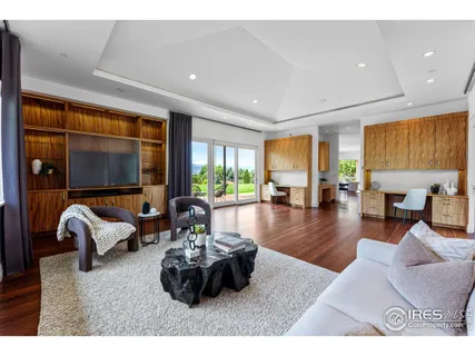 a living room with furniture floor to ceiling window and flat screen tv
