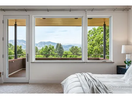a view of a bedroom with a bed and a window