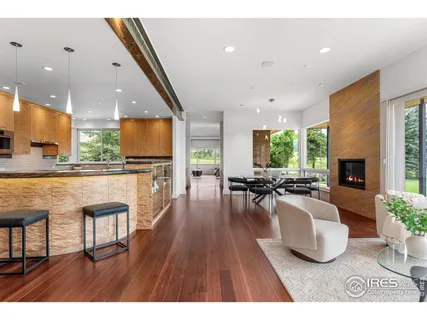 a living room with furniture a wooden floor and a large window