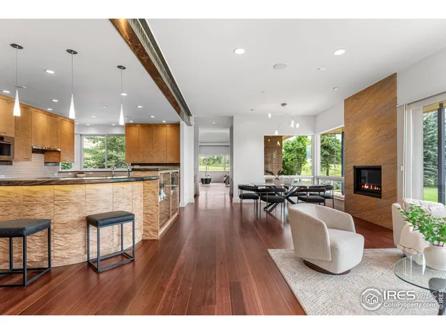 a living room with furniture a wooden floor and a large window
