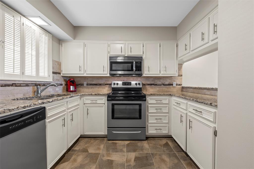 2901 Lake Shore Drive, Unit 405 Waco, TX 76708 - Photo 11 of 31 a kitchen with granite countertop white cabinets and white appliances