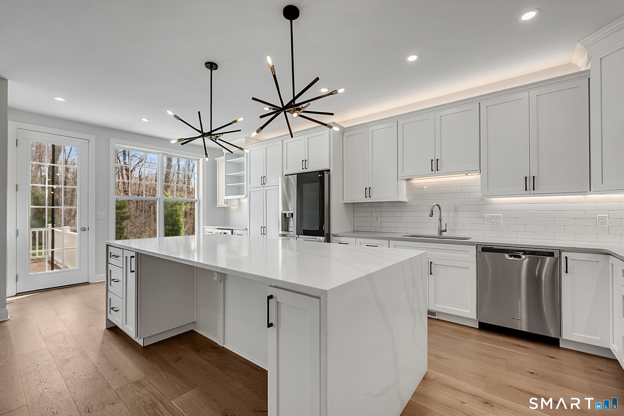 193 Ridgewood Drive, Unit 193 Middlebury, CT 06762 - Photo 13 of 40 a kitchen with stainless steel appliances granite countertop a sink a stove a refrigerator and white cabinets with wooden floor