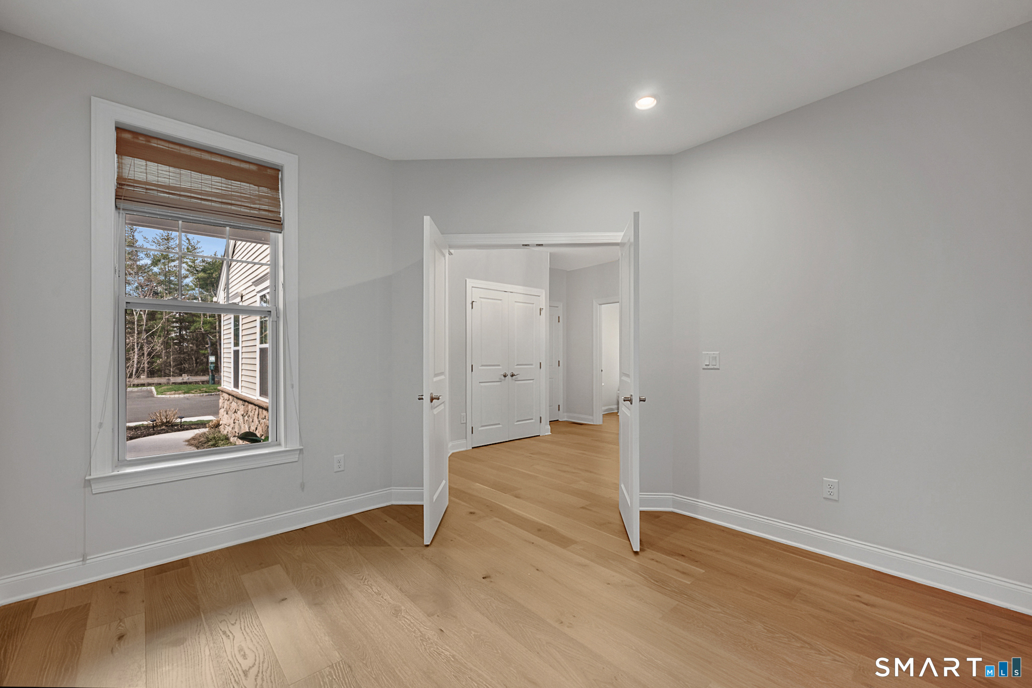 193 Ridgewood Drive, Unit 193 Middlebury, CT 06762 - Photo 4 of 40 an empty room with wooden floor and windows